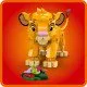 Lion King Simba modell forgó fejjel, mozgatható lábakkal és farokkal. Simba állva látható, készen katicabogarak, hernyók és csigák vadászatára, körülvéve az afrikai szavanna természetes elemeivel.