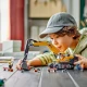 LEGO építőipari kotrógép univerzális karral és markolattal, amely készen áll az építkezésen nehéz terepen és nehéz terhek kezelésére.