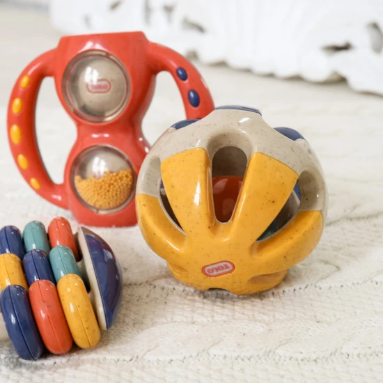 Színes golyó alakú csörgő lyukakkal, hogy a baba könnyen megfoghassa