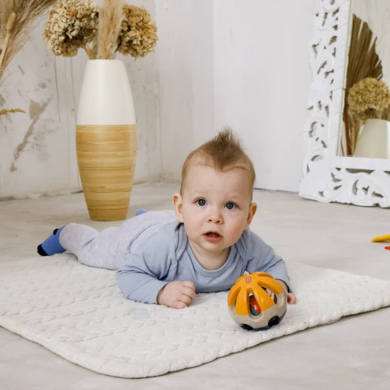 Színes golyó alakú csörgő lyukakkal, hogy a baba könnyen megfoghassa