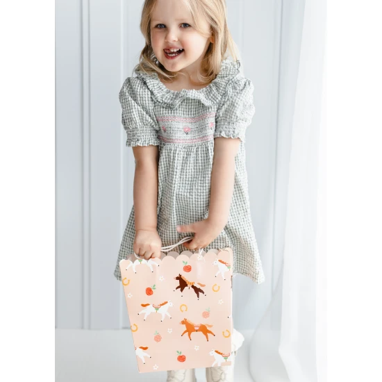 Rózsaszín ajándéktáska aranyos lómotívummal.